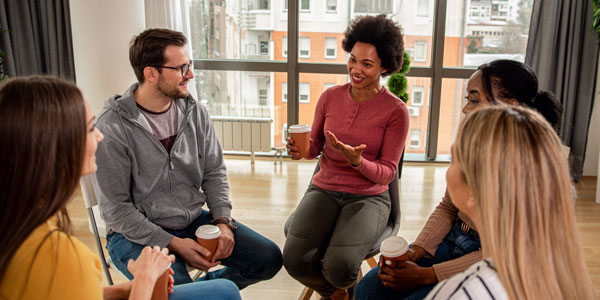 Diverse Group Of People Sitting In Circle In Group Therapy Sessi