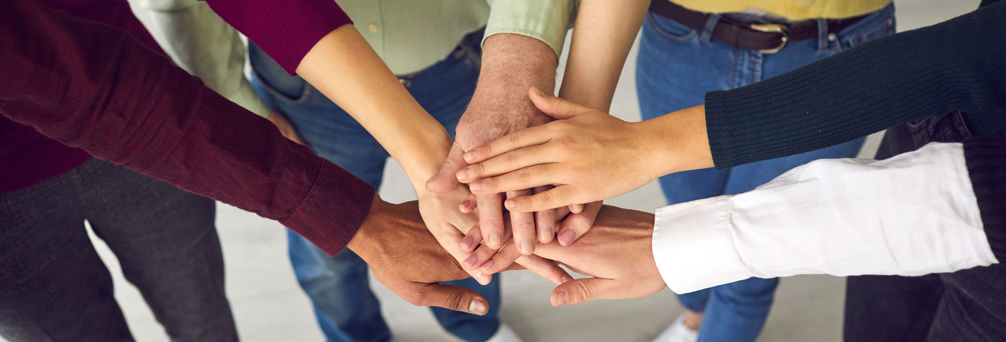 People Of Different Ages And Nationalities Fold Their Arms As A Symbol Of Cooperation.